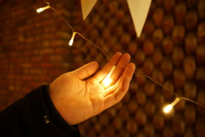 Close-up of person holding illuminated lighting equipment