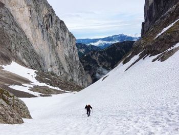 Man walking on snowcapped mountains during winter