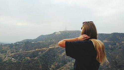 Woman photographing through mountain landscape