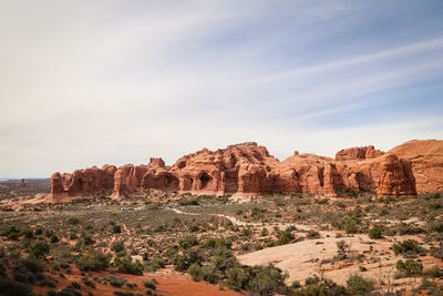 Rock formations on landscape against cloudy sky