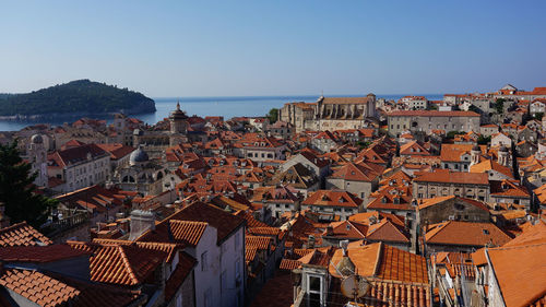 High angle view of townscape by sea against clear sky