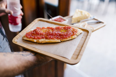 Waiter serving tomato sandwich in coffee shop