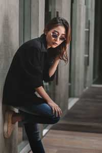 Portrait of woman standing against wall