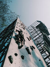 Low angle view of man on metallic structure against sky
