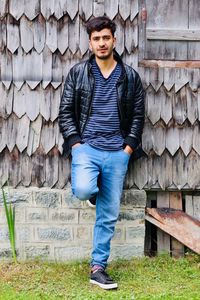 Portrait of young man standing against wall