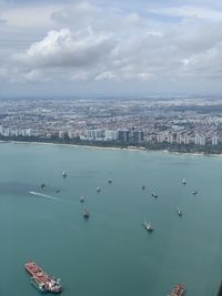 High angle view of cityscape by sea against sky