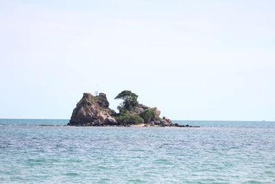 Scenic view of rocks in sea against clear sky