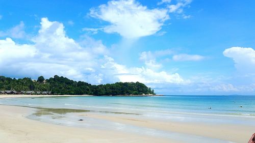 Scenic view of beach against blue sky