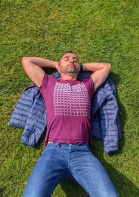 High angle view of man sleeping on grassy field