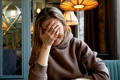 Young woman using mobile phone while sitting at home