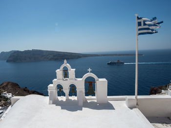 Building by sea against clear blue sky