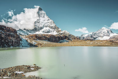 Scenic view of lake and snowcapped mountains against sky