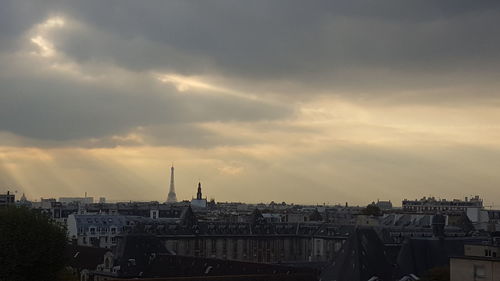 View of cityscape against cloudy sky