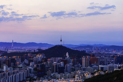 Buildings in city against sky during sunset