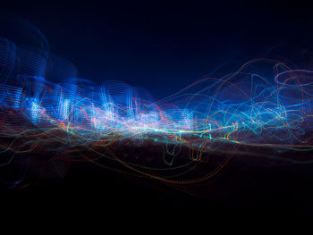 Illuminated light trails over black background
