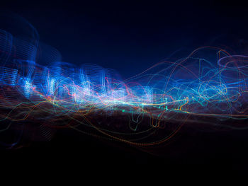 Illuminated light trails over black background