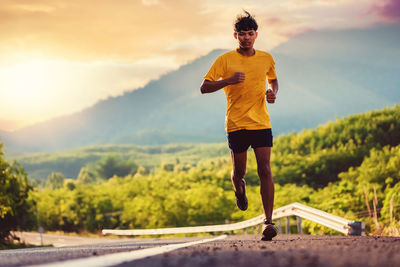 Full length of young man running against sky