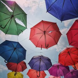 Low angle view of umbrellas hanging against sky