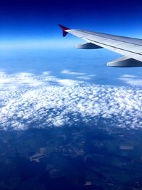 Aerial view of airplane wing against blue sky