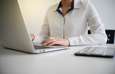 Midsection of man using laptop on table