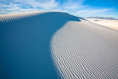 Scenic view of sand dunes against sky