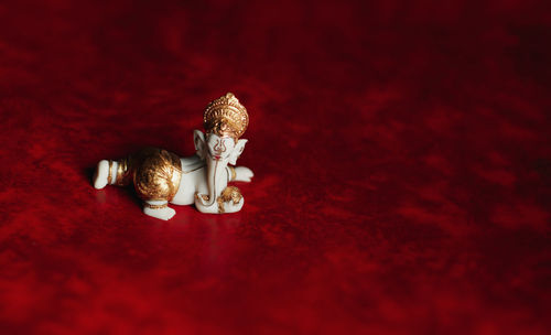 Close-up of ganesh statue on red background