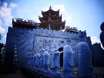 Rear view of people outside temple against building