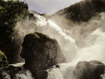 Scenic view of waterfall against sky