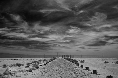 Empty road in desert against sky