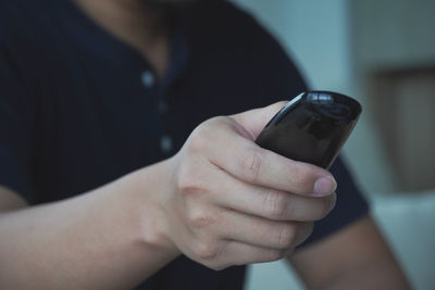 Midsection of man using mobile phone