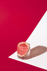Close-up of drink on table against red background