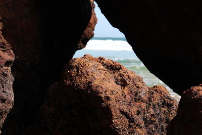 Rock formation in sea against sky