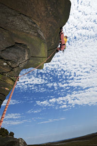 Woman climbing at windgather rocks in the british peak district