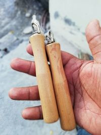 Cropped hand holding jump rope over footpath