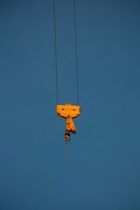 Low angle view of yellow flag against clear blue sky