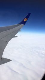 Close-up of airplane wing against blue sky