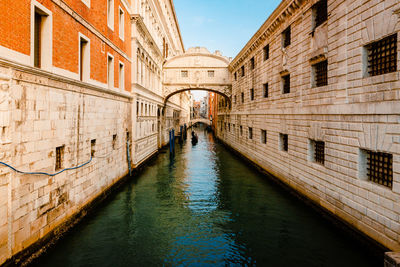 The famous bridge of sighs, in baroque style, with gondola crossing the canal