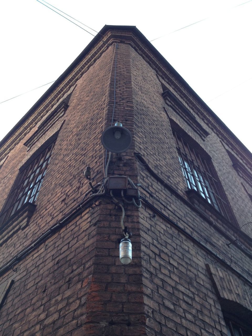 building exterior, architecture, built structure, low angle view, window, building, city, brick wall, tower, sky, tall - high, street light, day, clear sky, outdoors, no people, modern, residential building, office building, cable