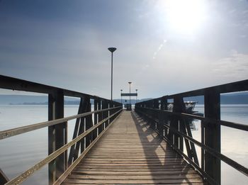 Footbridge over sea against sky