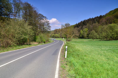 Road amidst trees against sky