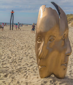 Close-up of sunglasses on beach against sky