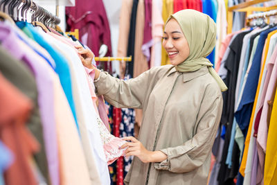 Young woman wearing hijab shopping clothes at store