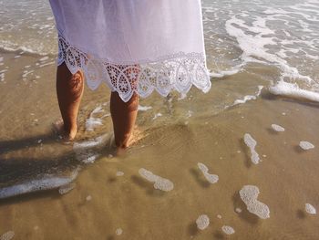 Low section of woman standing on beach