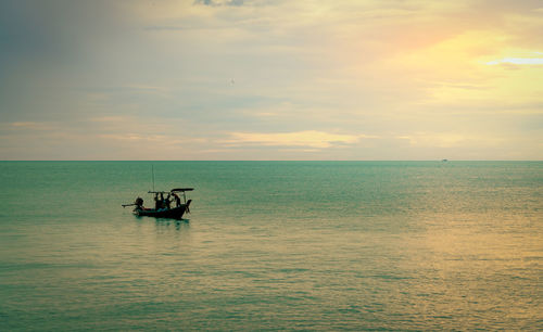 Beautiful tropical sea in the morning with golden sunrise sky. fisherman in long tail boat.