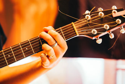 Cropped hand of woman playing guitar