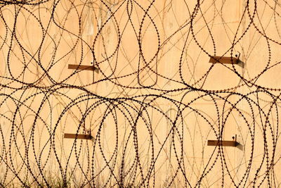 View of barbed wire fence against wall