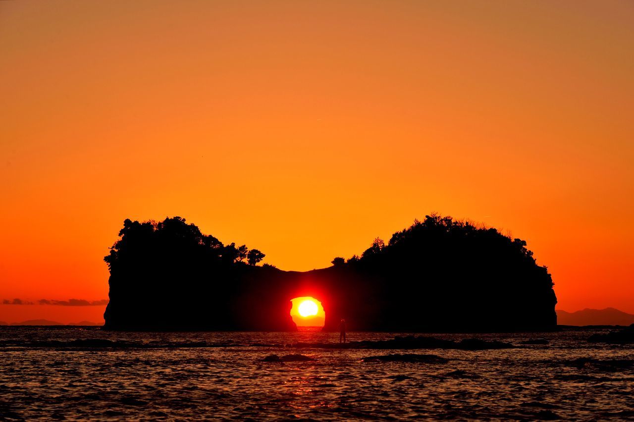 sunset, water, sea, orange color, scenics, tranquil scene, silhouette, beauty in nature, tranquility, waterfront, idyllic, nature, sun, clear sky, sky, copy space, horizon over water, rippled, mountain, tree