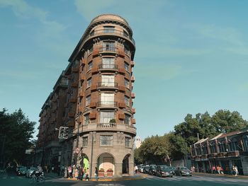 Building by road against sky in city