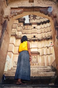 Rear view of woman standing by staircase