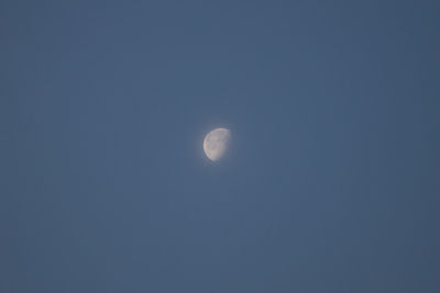 Low angle view of moon against blue sky